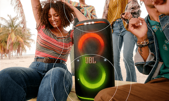 JBL - CE - A group of people partying at the beach while listening to music from JBL Partybox Stage 120 speaker