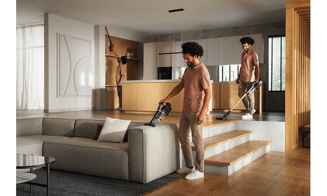 Miele Duoflex HX1 trådløs stavstøvsuger som brukes av en mann til å støvsuge en sofa