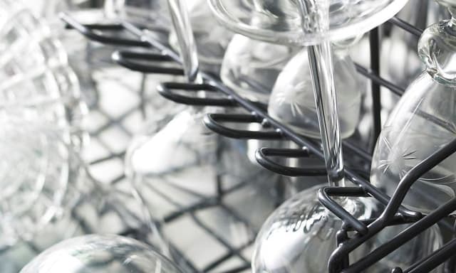 Wine glasses upside down inside a dishwasher