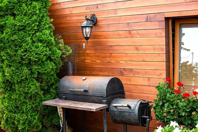 Rostig grill framför en stuga