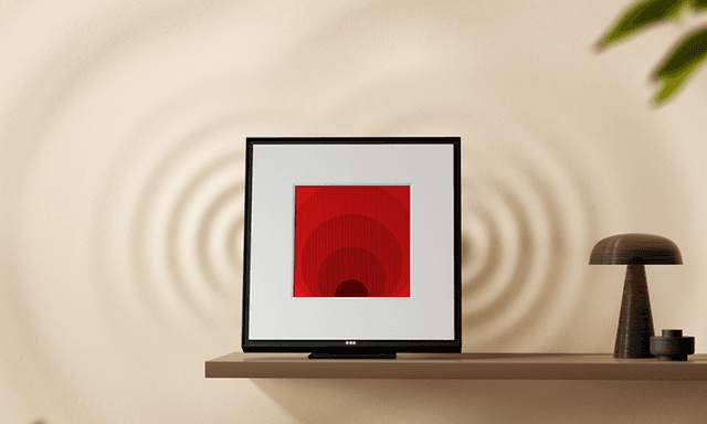 Samsung Music Frame on wall shelf next to a lamp