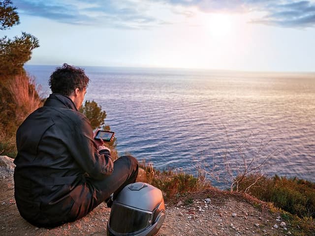 Motorsyklist som tar seg en pause på en strand