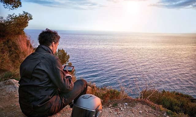 Motorsyklist som tar seg en pause på en strand