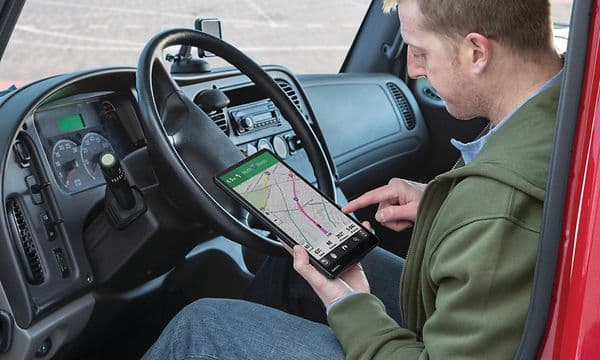 Person i lastebil som leter opp rute på GPS