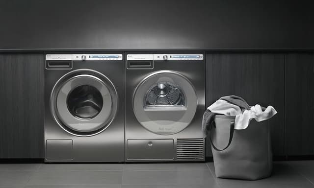 Professional washing machine and dryer in stainless steel placed next to each other