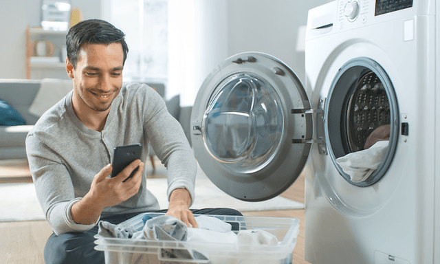 Mann som bruker Jeans-programmet på en Beko-tørketrommel