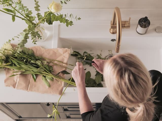 Klassisk køkken fra Epoq: Kvinde binder en blomsterbuket et Blue Grey Heritage-køkken fra Epoq