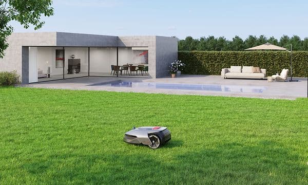 Dreame robotgressklipper på gården til et moderne hus