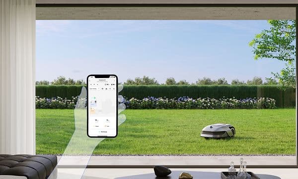 Illustrated hand holding phone in their with app for controlling Dreame lawn mower