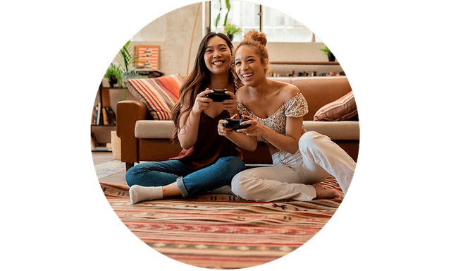 CS - Support agreement gaming - Two young women on the floor in a living room holding controllers for gaming