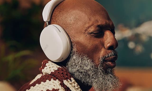Mand der lytter til musik med Sonos Ace-hovedtelefoner