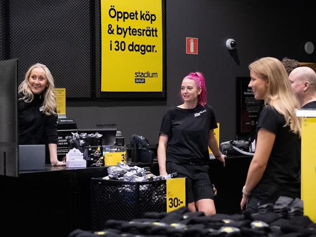 Butikschef Anna Bendréus kör en genomgång fr personalen framför skärmen.