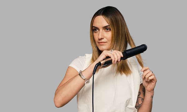 Remington ONE Straight & Curl Style brukes av kvinne som retter håret sitt