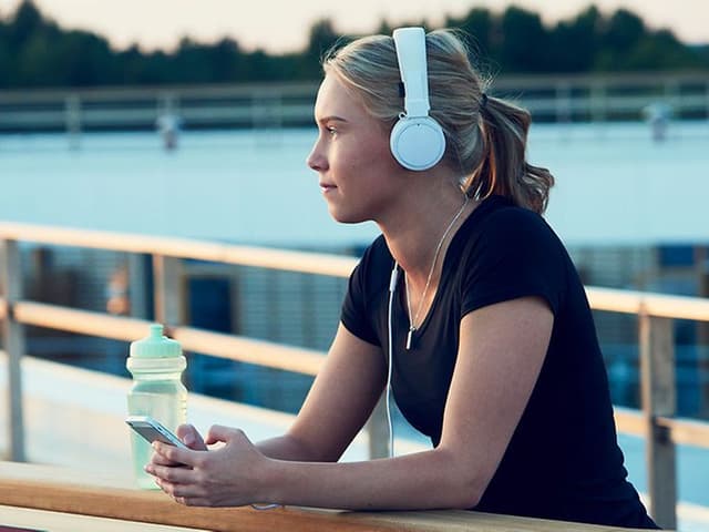 Kvinde, der lytter til en podcast på en løbetur