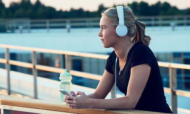 Kvinde, der lytter til en podcast på en løbetur