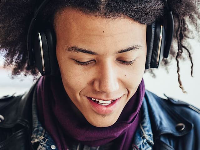 En person, der lytter til podcast med hovedtelefoner på.