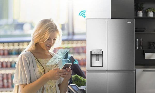 Hisense kjøleskap med AdaptTech og en kvinne som kommuniserer med det med ConnectLife på telefonen