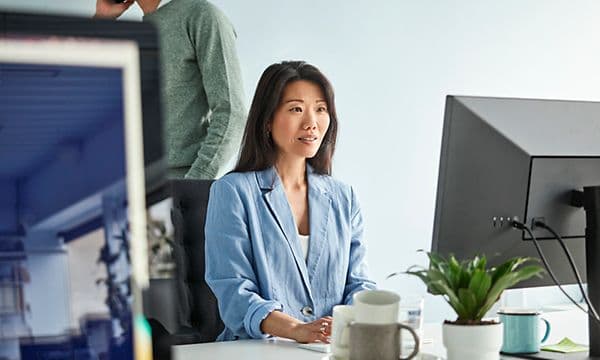 Kvinne sitter i kontoret og jobber
