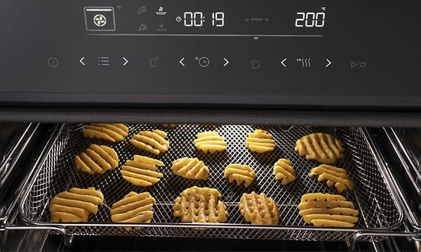 Hisense ovn med AirFry-funktion tilbereder kartofler i AirFry-bakken
