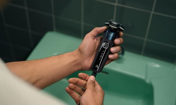 Philips S5000 barbermaskin i hånden på en mann