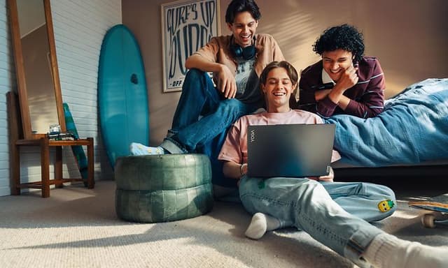 Tre unge menn ser på en Lenovo bærbar PC