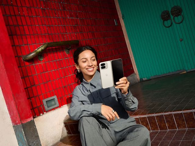 Google - Pixel 9 Pro Fold - Smiling woman holding Pixel 9 Pro Fold in front of her