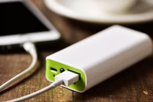 Powerbank ved siden af en computer på et bord