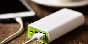 Powerbank ved siden af en computer på et bord