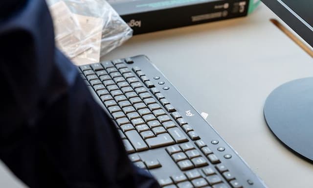 En person placerar ett Logi-tangentbord på ett skrivbord
