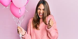 Kvinne holder rosa ballonger