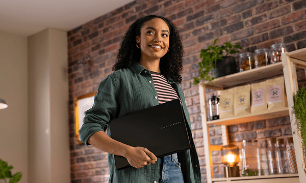 Woman holding Asus Vivobook S 14 M5406 laptop under her arm