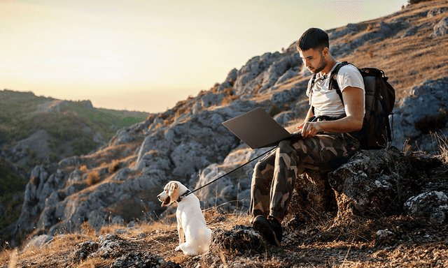 Asus - Computing - Man with his dog in the mountains and Asus ProArt P16 H7606 laptop on his lap