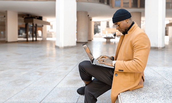 Mand sidder på trappe med Asus Vivobook S 15 laptop