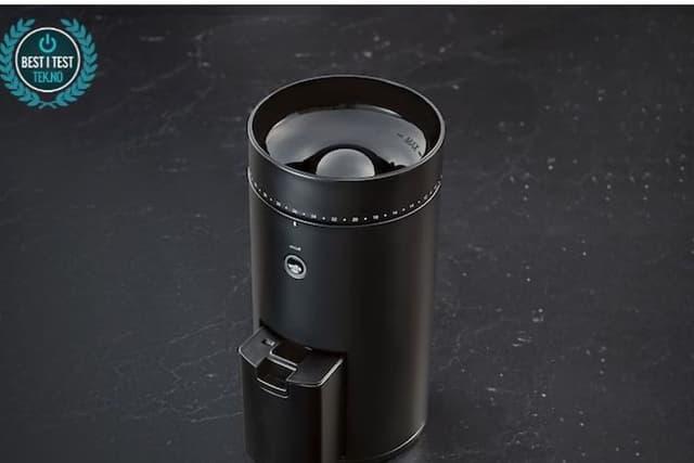 A Wilfa coffee grinder next to coffee beans being weighed on a digital scale, ready for grinding