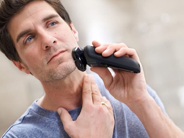 Bedst i test barbermaskine: Spejlbillede af mand, der barberer sig med barbermaskine