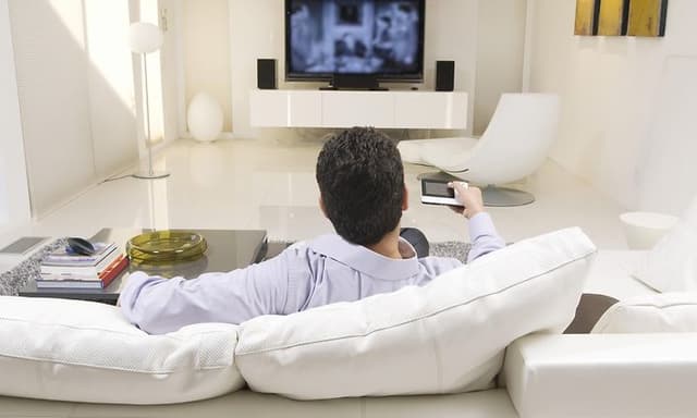 Mann ser på TV i en moderne stue
