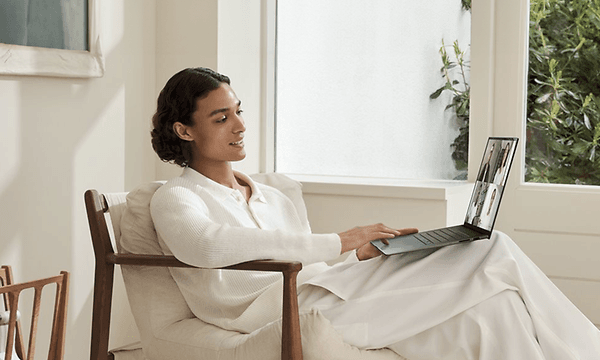 Nainen ja Asus Zenbook S 14 -kannettava sylissään