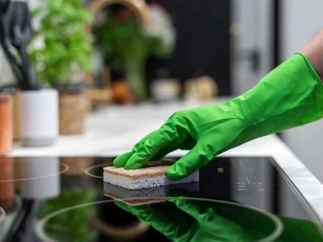 Closeup of a person cleaning an induksjon hob.