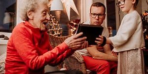 Grandma opening a gift with family surrounding her