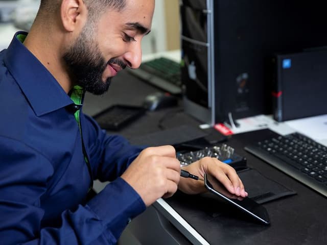 B2B - Sustainability - Elkjøp service employee fixing a smartphone