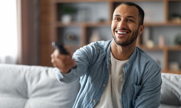 Man in sofa with TV remote