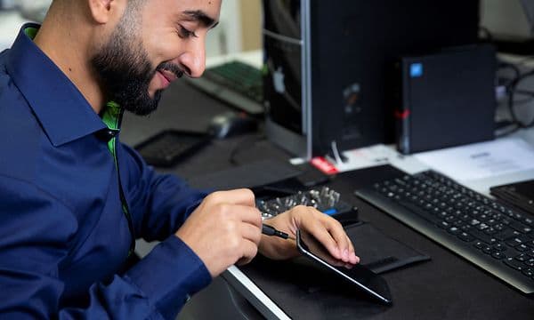 Medarbejder i Elgiganten reparerer en mobiltelefon