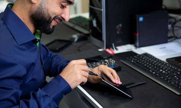 Servicemedarbetare fixar en smartphone