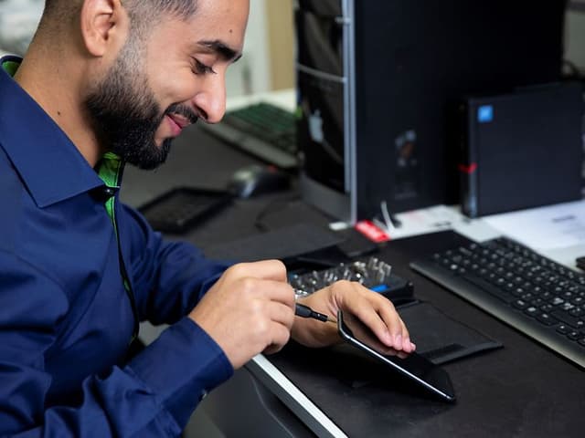 Servicemedarbetare fixar en smartphone