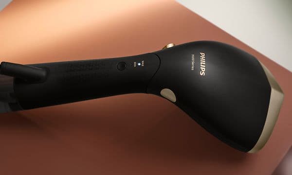 Handhållen steamer - Svart Philips steamer mot brun bakgrund