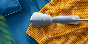 Handhållen steamer - Ljusblå Philips steamer används på gult tyg.