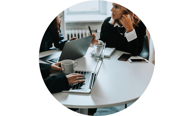 Three women working on their laptops while having a meeting