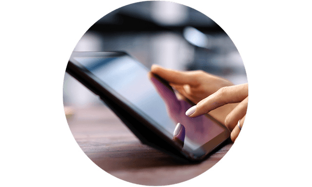 Woman using tablet device she holds in her hand