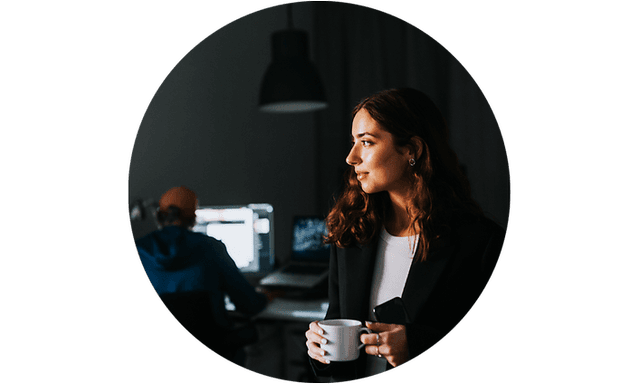Business woman standing in office holding a white coffee cup
