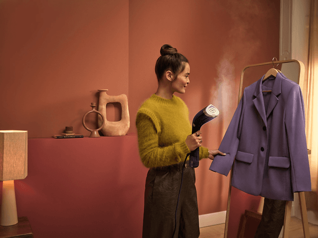 Bedst i test steamer: Kvinde bruger tøjdamper på en blazer